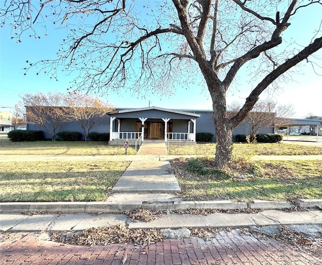 ranch-style house featuring covered porch and a front lawn