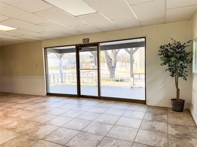 spare room featuring light tile patterned floors and a drop ceiling