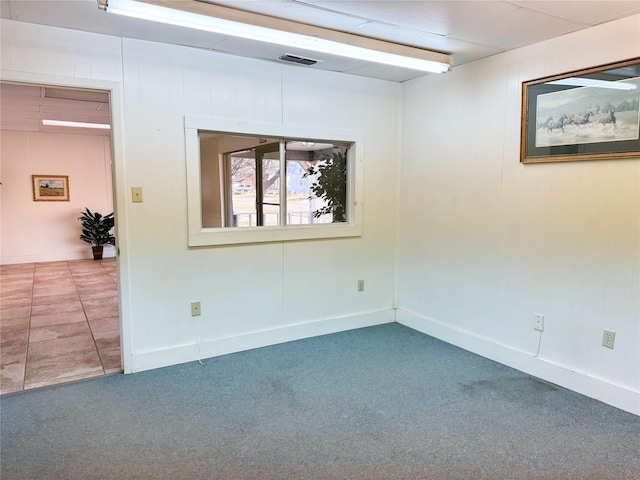 empty room featuring carpet, visible vents, and baseboards