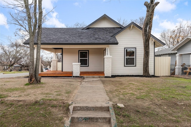 view of front of home featuring fence, a porch, and roof with shingles