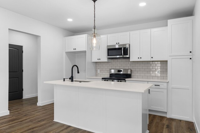 kitchen featuring white cabinets, dark wood finished floors, stainless steel appliances, light countertops, and a sink