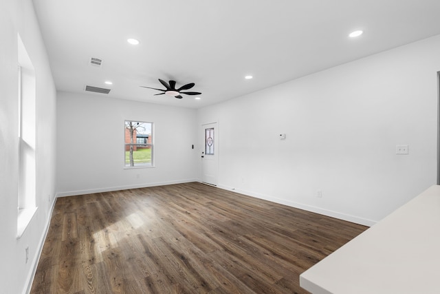 spare room with baseboards, visible vents, dark wood-type flooring, and recessed lighting