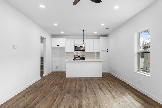 kitchen with white cabinetry, baseboards, light countertops, appliances with stainless steel finishes, and decorative backsplash