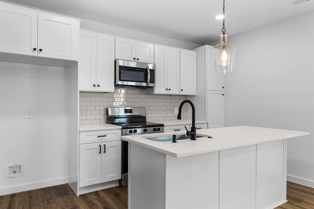 kitchen featuring stainless steel appliances, a sink, white cabinets, tasteful backsplash, and dark wood finished floors