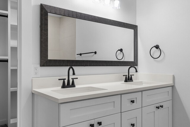 full bathroom with double vanity and a sink