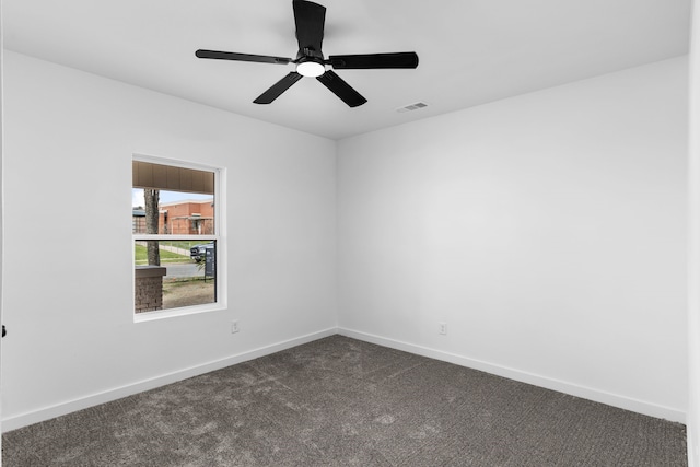 empty room with dark colored carpet, visible vents, ceiling fan, and baseboards