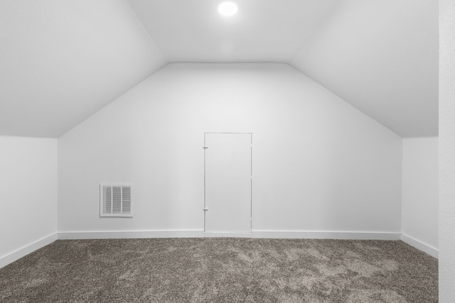 additional living space featuring carpet, visible vents, vaulted ceiling, and baseboards
