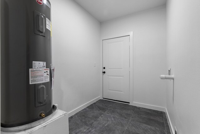 doorway to outside with electric water heater and baseboards