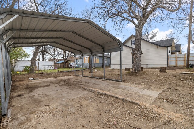 view of vehicle parking featuring a carport and fence