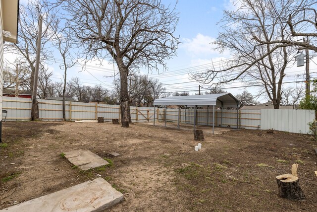 view of yard with a carport and a fenced backyard
