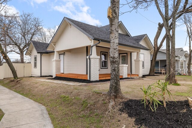 view of front of house with a shingled roof and fence