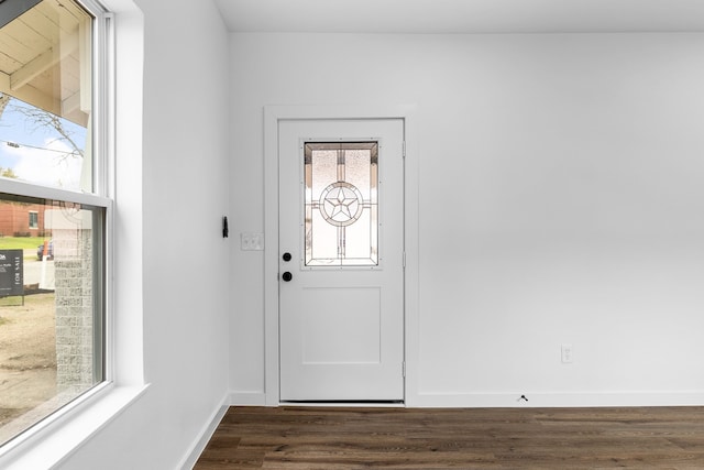 doorway to outside with dark wood-style floors and baseboards