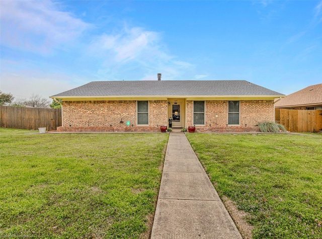 ranch-style house featuring a shingled roof, brick siding, fence, and a front lawn