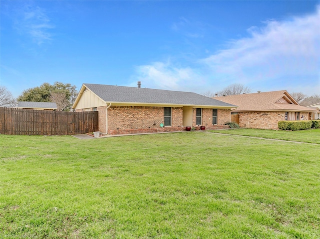 single story home with brick siding, fence, and a front lawn