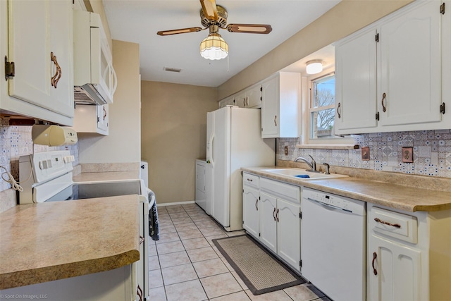 kitchen with light tile patterned floors, visible vents, white cabinets, a sink, and white appliances