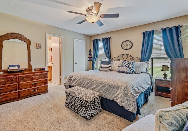 bedroom with carpet floors, ceiling fan, and ensuite bath