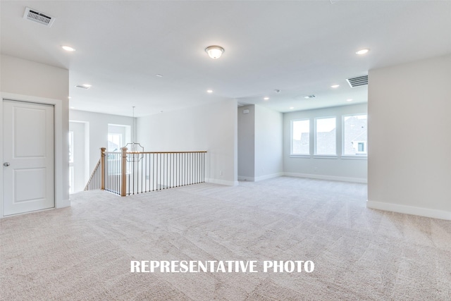 carpeted spare room with baseboards, visible vents, and recessed lighting