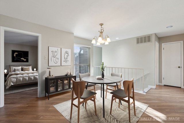 dining room featuring wood finished floors, baseboards, visible vents, recessed lighting, and a chandelier