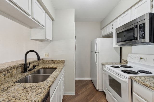 kitchen with a sink, stainless steel microwave, electric range, and white cabinetry