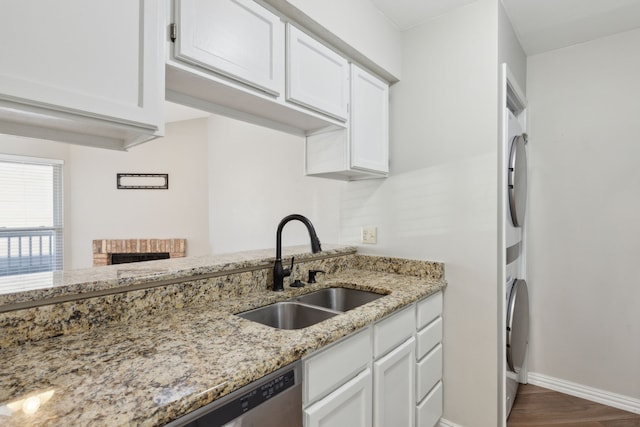 kitchen with a sink, wood finished floors, white cabinetry, baseboards, and light stone countertops