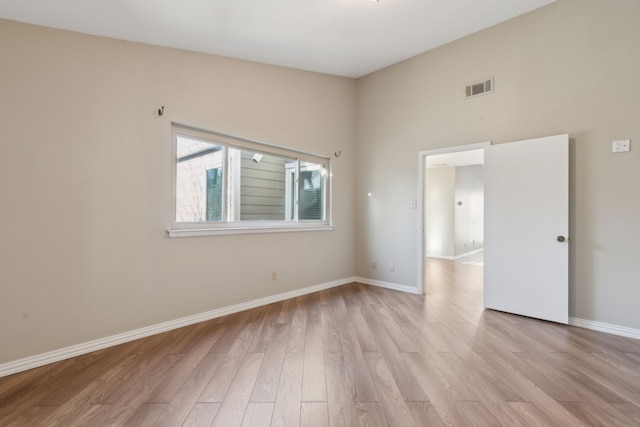 spare room featuring visible vents, light wood-type flooring, and baseboards