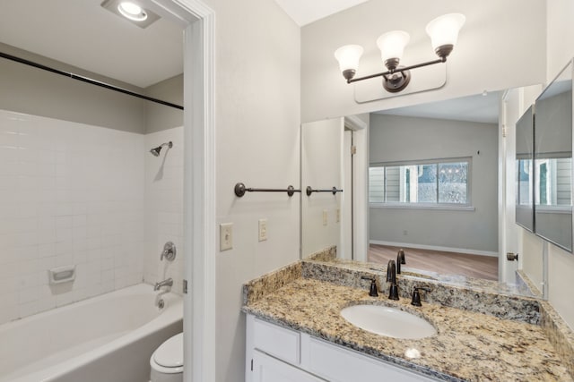 bathroom featuring baseboards, toilet, vanity, and shower / tub combination