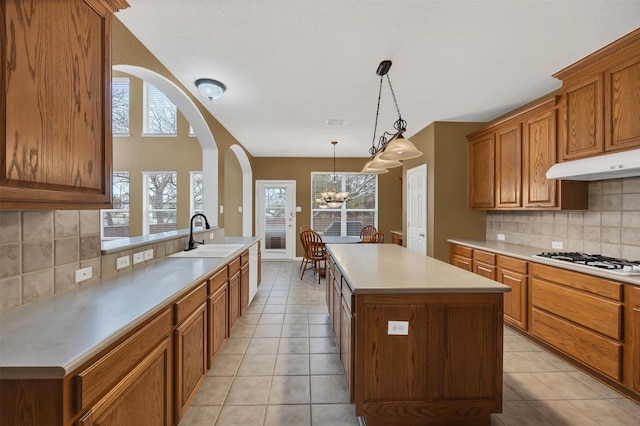 kitchen featuring white gas stovetop, light tile patterned floors, light countertops, and a sink