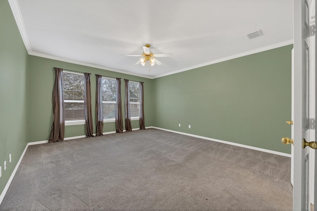 carpeted empty room featuring ceiling fan, ornamental molding, visible vents, and baseboards