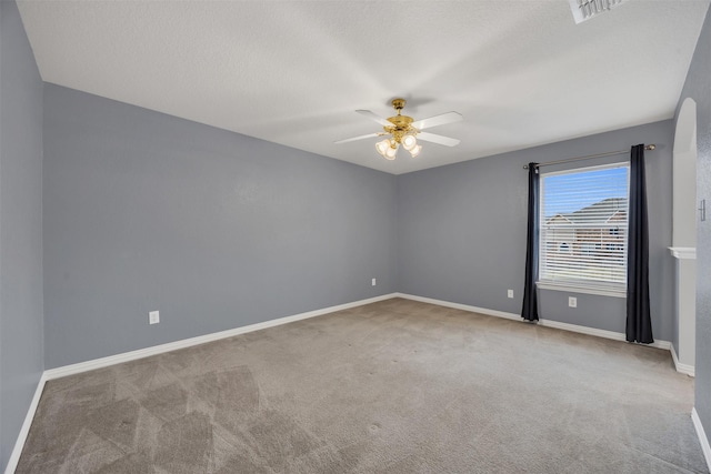 unfurnished room with a ceiling fan, carpet flooring, visible vents, and baseboards