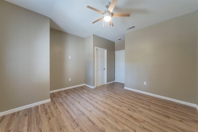 unfurnished room with light wood-type flooring, ceiling fan, visible vents, and baseboards