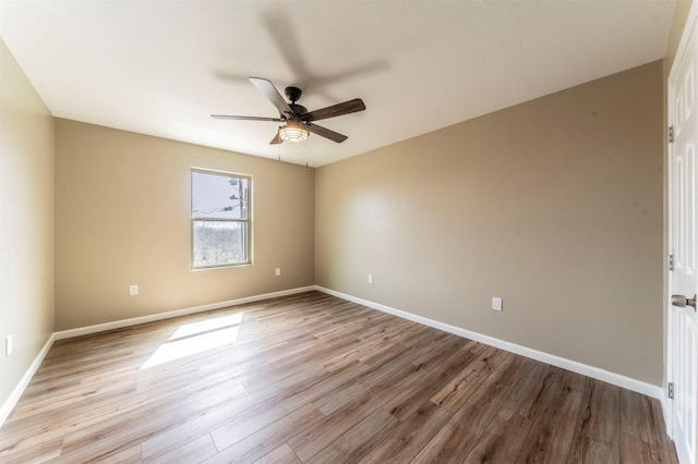 unfurnished room with a ceiling fan, baseboards, and wood finished floors