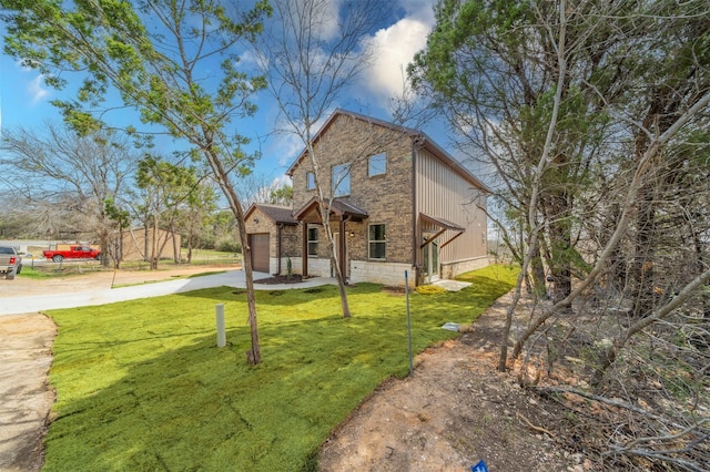 view of front facade featuring brick siding, a garage, stone siding, driveway, and a front lawn