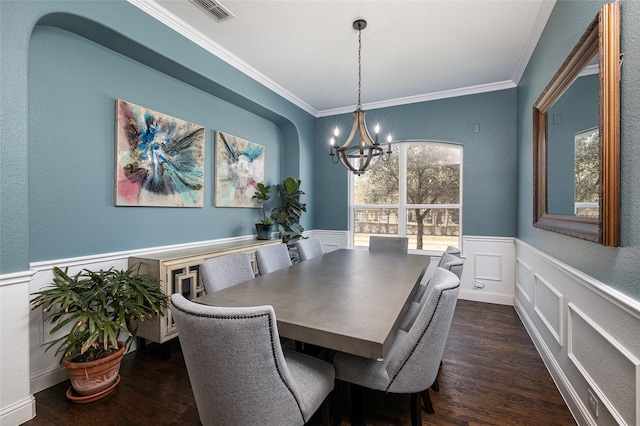 dining space with a notable chandelier, dark wood-type flooring, visible vents, wainscoting, and crown molding