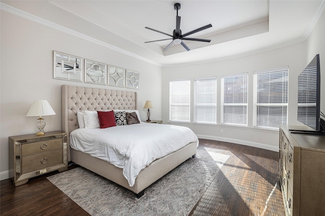 bedroom with crown molding, dark wood-style flooring, a raised ceiling, and baseboards