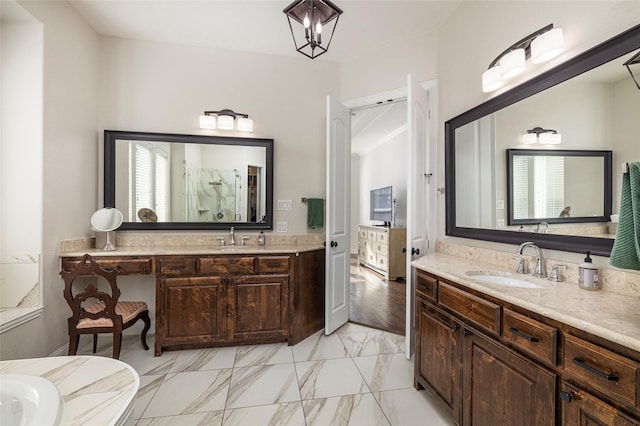 bathroom with a shower, marble finish floor, two vanities, and a sink