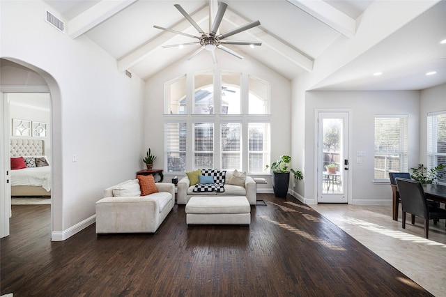 living room with arched walkways, beam ceiling, visible vents, wood finished floors, and high vaulted ceiling