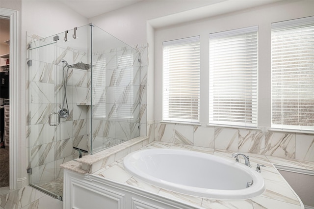 full bathroom with a marble finish shower and a bath