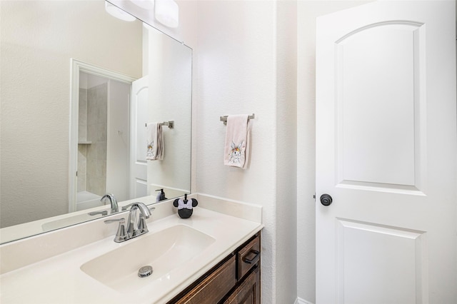 bathroom with a textured wall and vanity