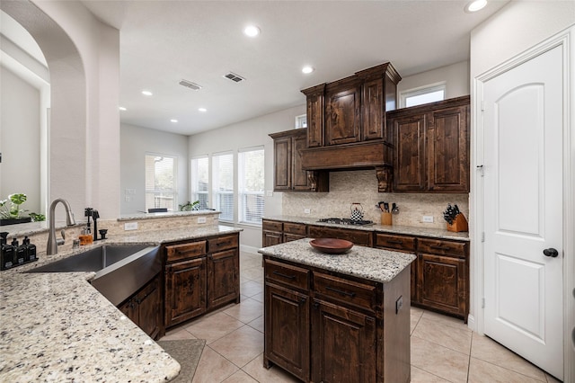 kitchen with visible vents, decorative backsplash, a sink, and light tile patterned flooring