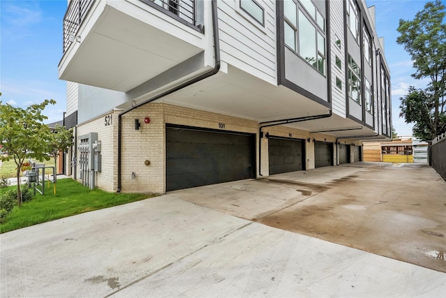 view of side of property featuring a garage and brick siding