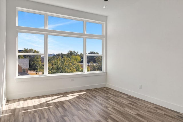 unfurnished room featuring recessed lighting, baseboards, and wood finished floors