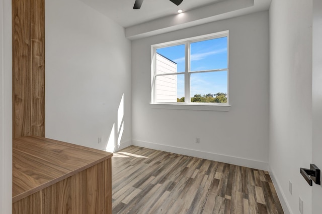 empty room featuring a ceiling fan, baseboards, and wood finished floors