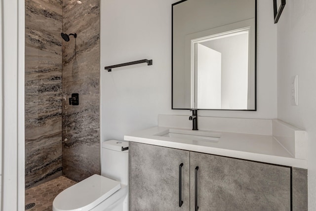 full bathroom featuring a stall shower, vanity, and toilet