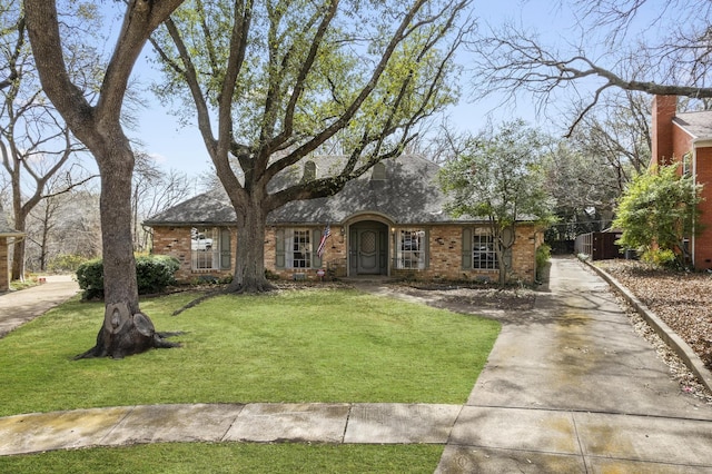 view of front facade featuring a front yard and brick siding