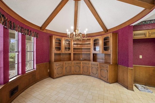 dining area featuring a wainscoted wall, wooden walls, vaulted ceiling with beams, and a notable chandelier