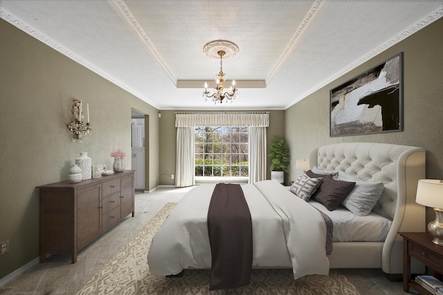 bedroom with light carpet, a textured wall, ornamental molding, a tray ceiling, and a chandelier