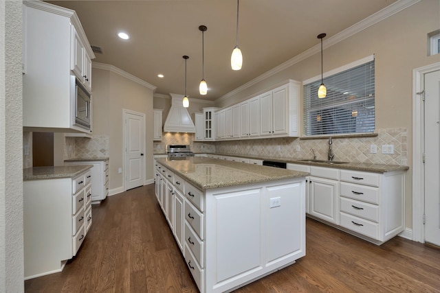 kitchen featuring stainless steel microwave, dark wood-type flooring, premium range hood, white cabinets, and a sink