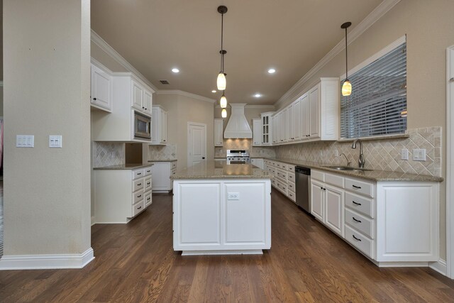 kitchen with a center island, appliances with stainless steel finishes, dark wood-style floors, white cabinets, and a sink