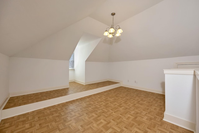 additional living space with baseboards, an inviting chandelier, and vaulted ceiling