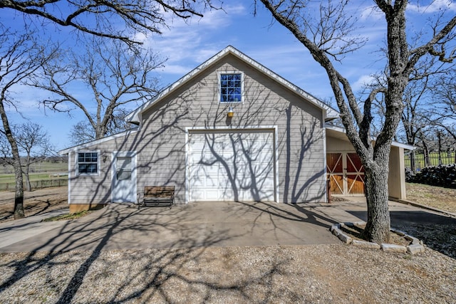 view of home's exterior featuring a garage, an outbuilding, and aphalt driveway